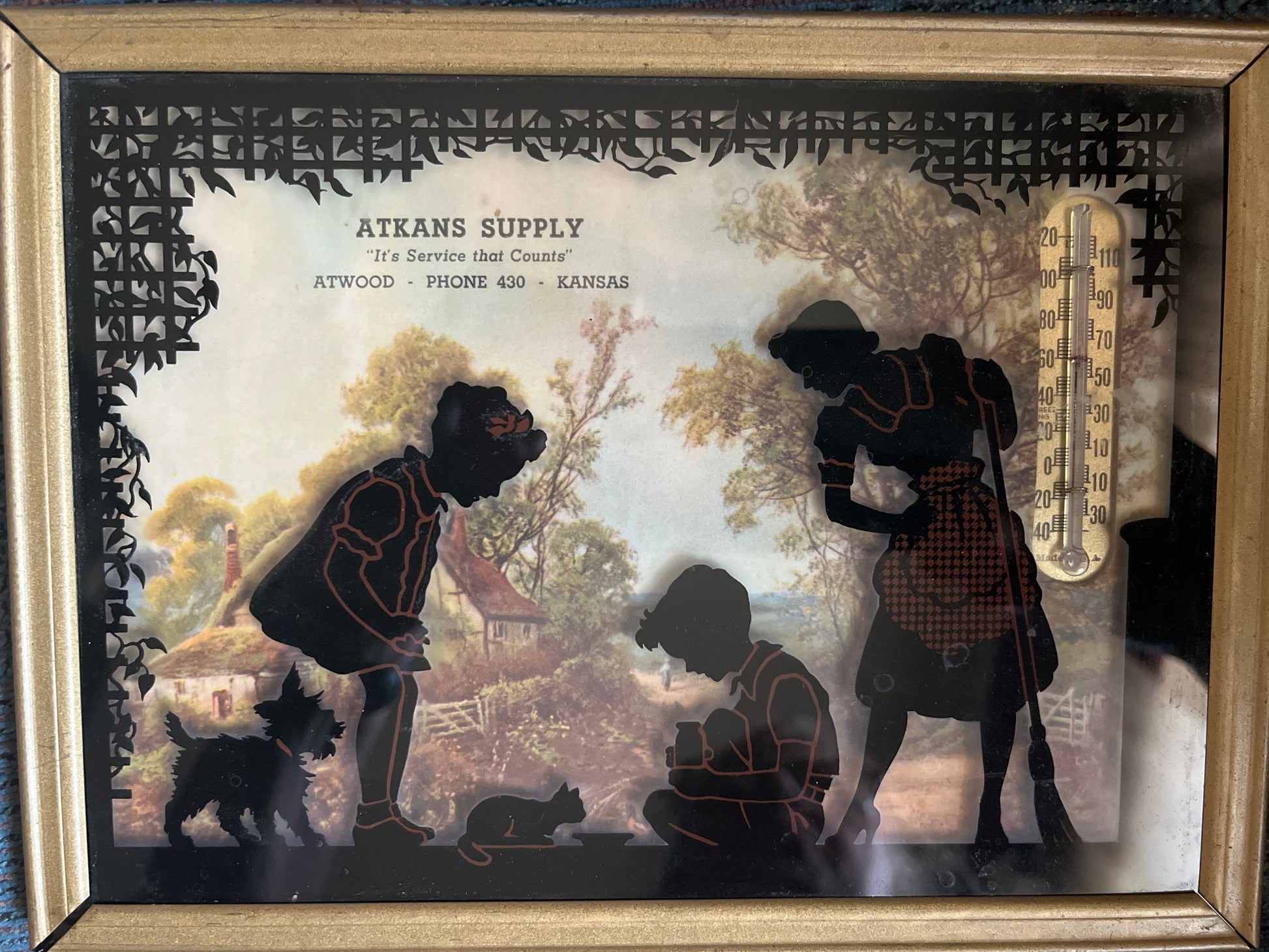 Framed artwork with silhouettes of people and animals, featuring the brand 'Atkans Supply'.