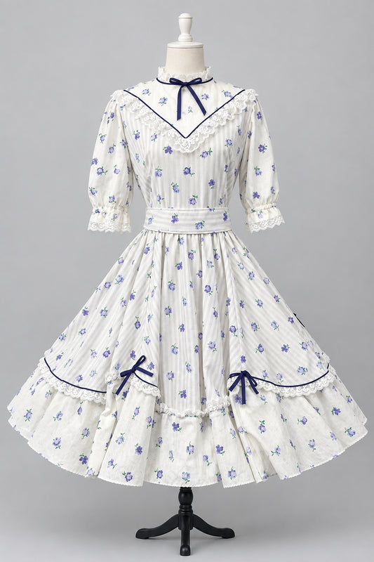 A white Victorian-style Lolita dress with Lavender floral prints and dark purple trim, displayed on a mannequin in studio