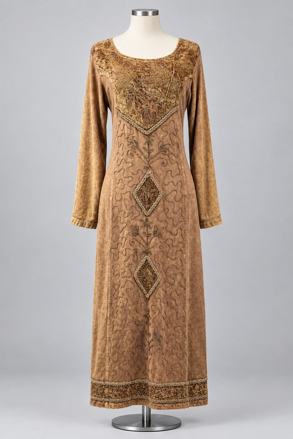 A brown velvet long-sleeve dress with intricate gold embroidery and geometric diamond patterns, displayed on a mannequin against a white fabric backdrop.